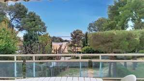 A balcony with a view of trees and a distant landscape. - Cross-apartment with terrace - 6 guests (Bormes-les-Mimosas)