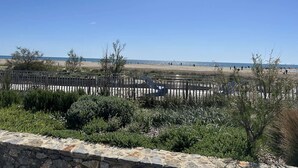 A coastal view with a stone wall, vegetation, and a clear sky. - Apartment with sea view, parking - 4 guests (Fleury-Saint-Pierre-la-Mer)
