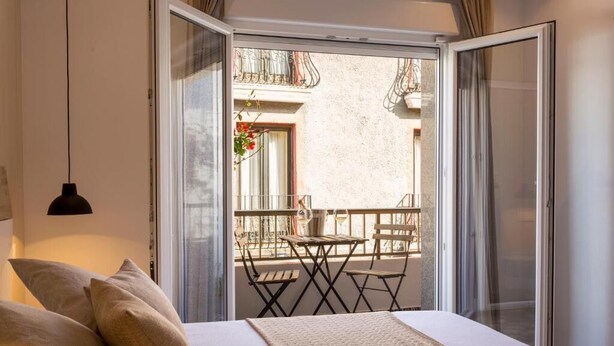 A bedroom with a bed, a window, and a balcony with a table and chairs. - Room Boutique 32 (Dénia)