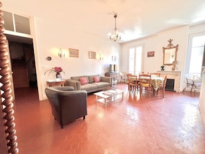 Ein geräumiges Wohnzimmer mit Sofa, Couchtisch und Essbereich.