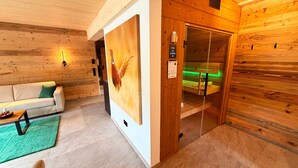 Ein Holzinnenraum mit einer Couch, einem Gemälde, einer Sauna und einer Bedienkonsole.