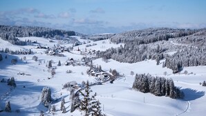 A snow-covered landscape with a small village, houses, and a church. - Forestum - Black Forest Luxury Apartments - Apartment Auerhahn with sauna (Sankt Blasien)