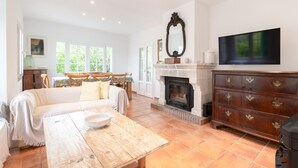 A spacious living room with a fireplace, a dining area with a table and chairs, and a large mirror on the wall. - Villa 'Herdain' with Mountain Views, Wi-Fi, and Air Conditioning (Mal Pas-Bon Aire)