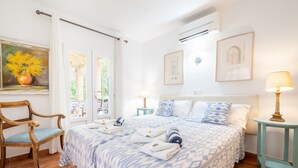 A bedroom with a bed, a chair, a bedside table, a lamp, and artwork on the walls. - Villa 'Herdain' with Mountain Views, Wi-Fi, and Air Conditioning (Mal Pas-Bon Aire)