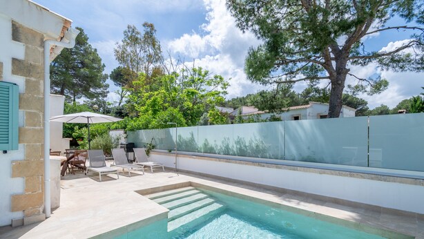 A swimming pool with steps leading into it, surrounded by a white wall and a glass fence. - Villa 'Herdain' with Mountain Views, Wi-Fi, and Air Conditioning (Mal Pas-Bon Aire)