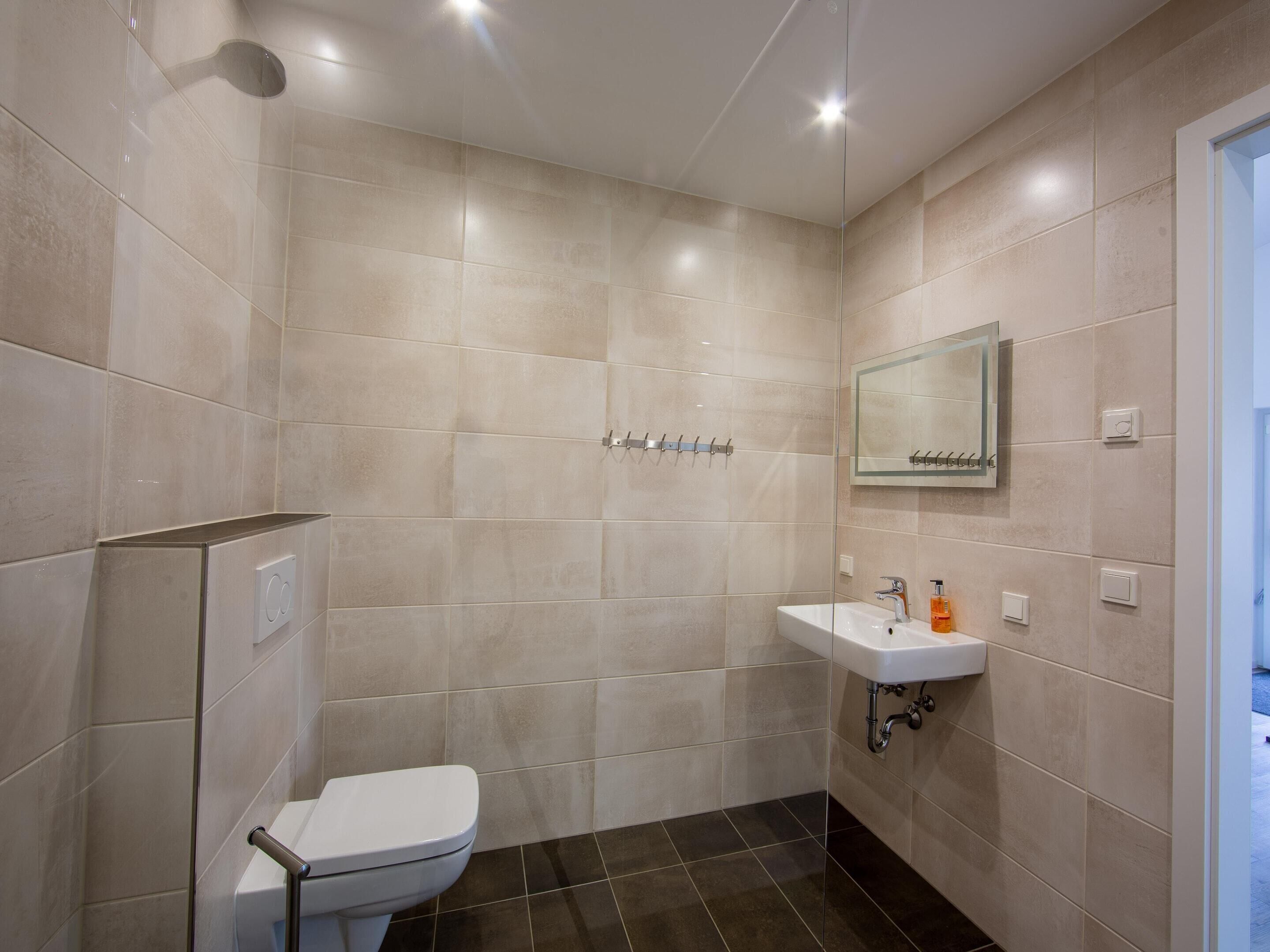 Un baño moderno con inodoro, lavabo y ducha.