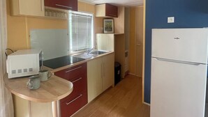A compact kitchen with a microwave, sink, and a refrigerator.