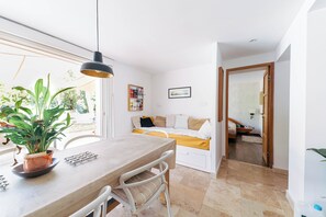 A modern kitchen with a dining table, chairs, a hanging light, and a potted plant. - La Villa des Criques Private Pool & Walking Beach (Saint-Raphaël)