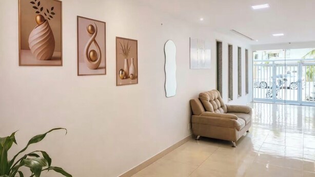 Un interior moderno con un sofá color beige, una obra de arte colgada en la pared y una planta en maceta.