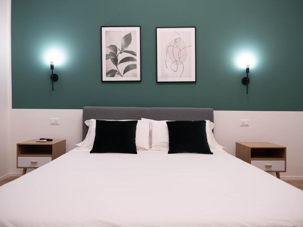 Een slaapkamer met een bed, twee nachtkastjes en twee wandlampen.