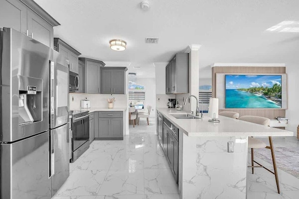 Spacious modern kitchen with stainless steel appliances, quartz countertops, and a large island perfect for cooking and gathering.