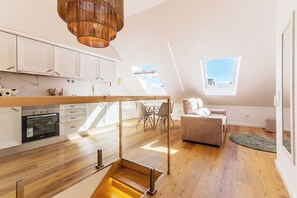 En moderne lejlighed med køkken, spiseplads og opholdsstue med udsigt.
