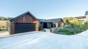 Una casa moderna con un ampio garage, una strada d'accesso coperta e un prato curato.