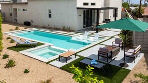 Uma casa moderna com piscina, área de estar externa e um pátio.