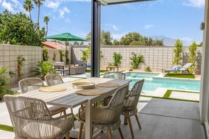 An outdoor patio with a pool, wicker furniture, and a view of the mountains. - 4 Bedroom Luxury Estate With Pool Spa Firepit (Indio)