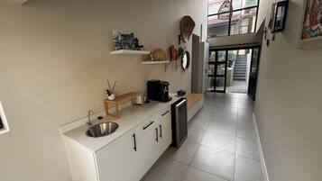Una cocina moderna con un lavamanos, encimera y una cafetera.