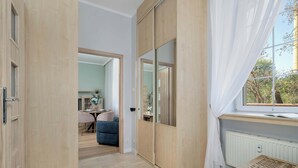 Une pièce dotée d’une porte coulissante, d’une fenêtre avec des rideaux, d’un radiateur et d’une table.