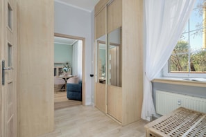 A room with a sliding door, a window with curtains, a radiator, and a table. - Modern Studio Near the Old Market Square | Near the Warta River | Smart TV (Poznań)