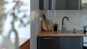 Une cuisine moderne avec un plan de travail en bois, un évier en acier inoxydable et une plante en pot.