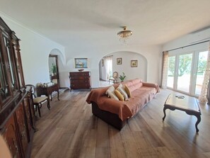 A spacious room with a large bed, wooden furniture, a chandelier, and large windows. - 5 bedroom villa with pool for vacation in Armação de Pêra (Armação de Pêra)