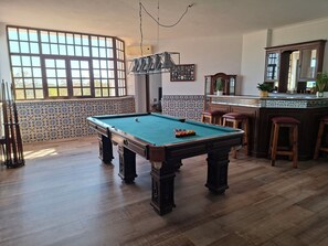 A pool table in a room with a large window, a bar area, and a tiled backsplash. - 5 bedroom villa with pool for vacation in Armação de Pêra (Armação de Pêra)