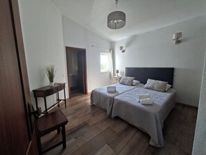 A bedroom with a large bed, bedside tables, a desk, a potted plant, and a view of the outside. - 5 bedroom villa with pool for vacation in Armação de Pêra (Armação de Pêra)