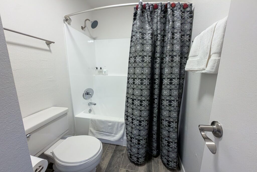 Ein Badezimmer mit Dusche, Toilette und Badewanne.
