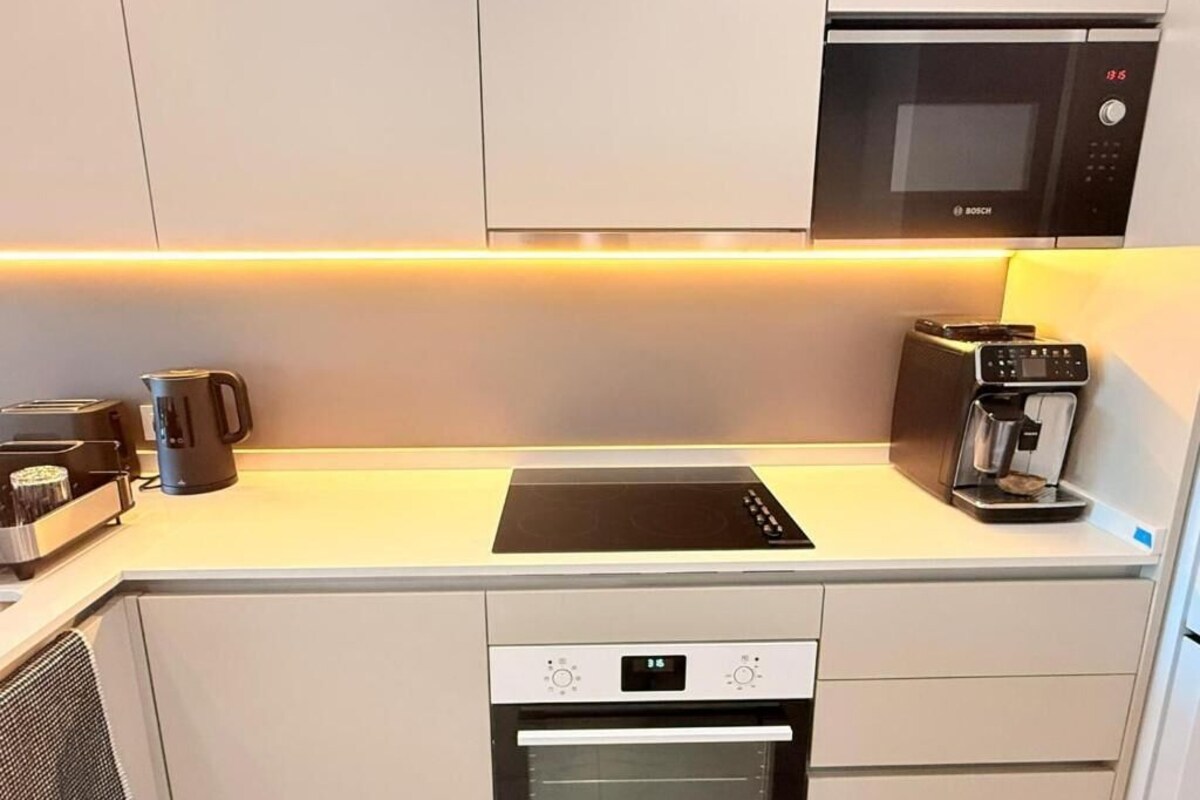 A modern kitchen with a built-in oven, microwave, and induction cooktop.