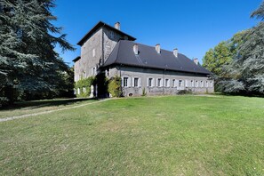 A large stone building with a symmetrical facade, multiple chimneys, and a well-maintained lawn. - Château with Private Park – Gîte du Tilleul – Exceptional Setting (Tournon)