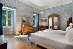 A bedroom with a large bed, dresser, and a mirror. - Château with Private Park – Gîte du Tilleul – Exceptional Setting (Tournon)