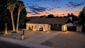 A modern house with a garage, a driveway, and a well-maintained garden. - Spacious Phoenix Oasis w/ Pool & Game Room (Phoenix)