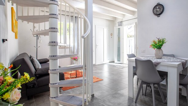 Ein modernes Interieur mit einer Wendeltreppe, einer Essecke und einem Wohnbereich.