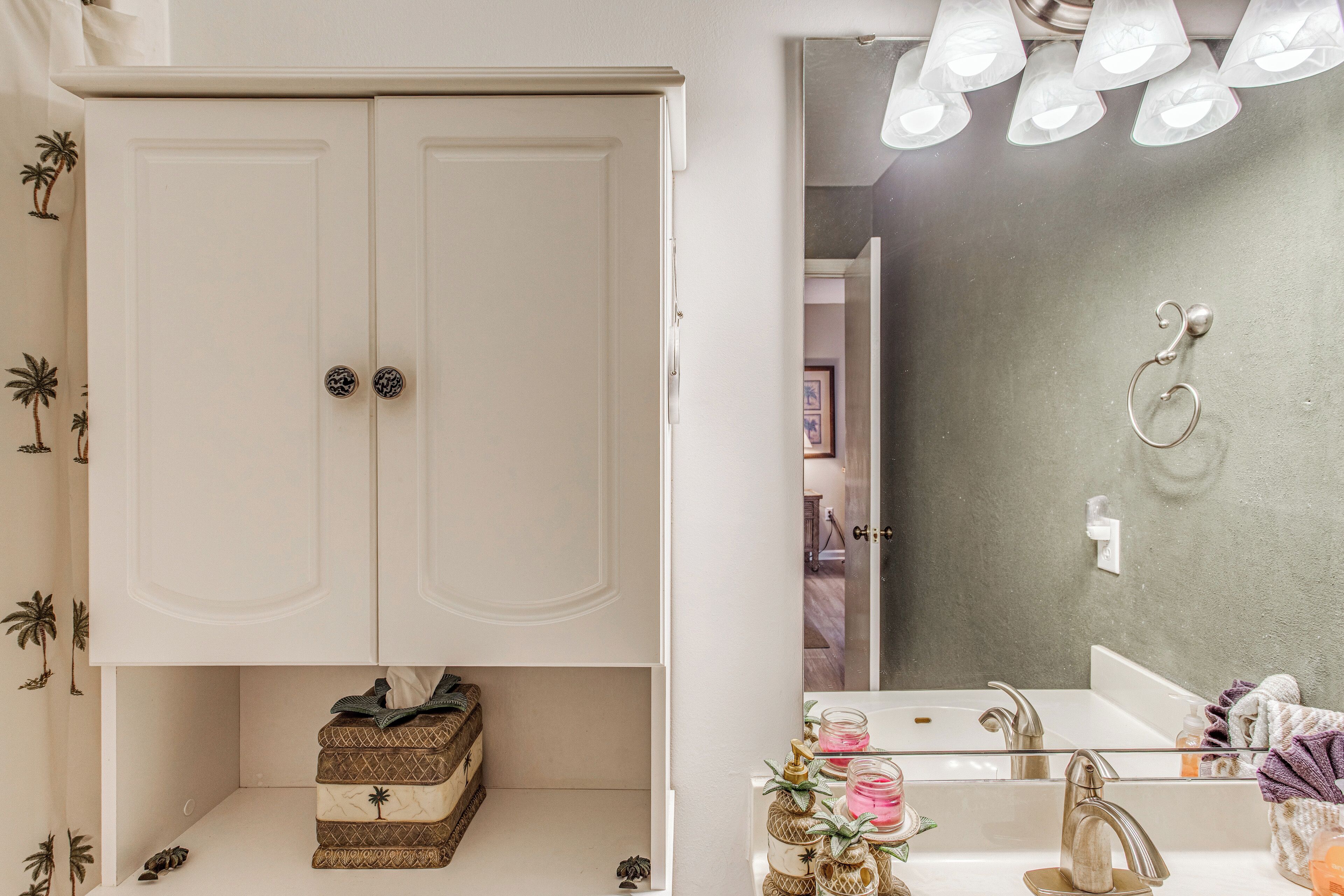 Une salle de bain avec un meuble-lavabo à deux vasques, un miroir, un lavabo et un porte-serviettes.