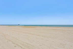 A wide sandy beach with a pier extending into the water. - Walk to Beach! North Myrtle Beach Condo w/ Balcony (North Myrtle Beach)