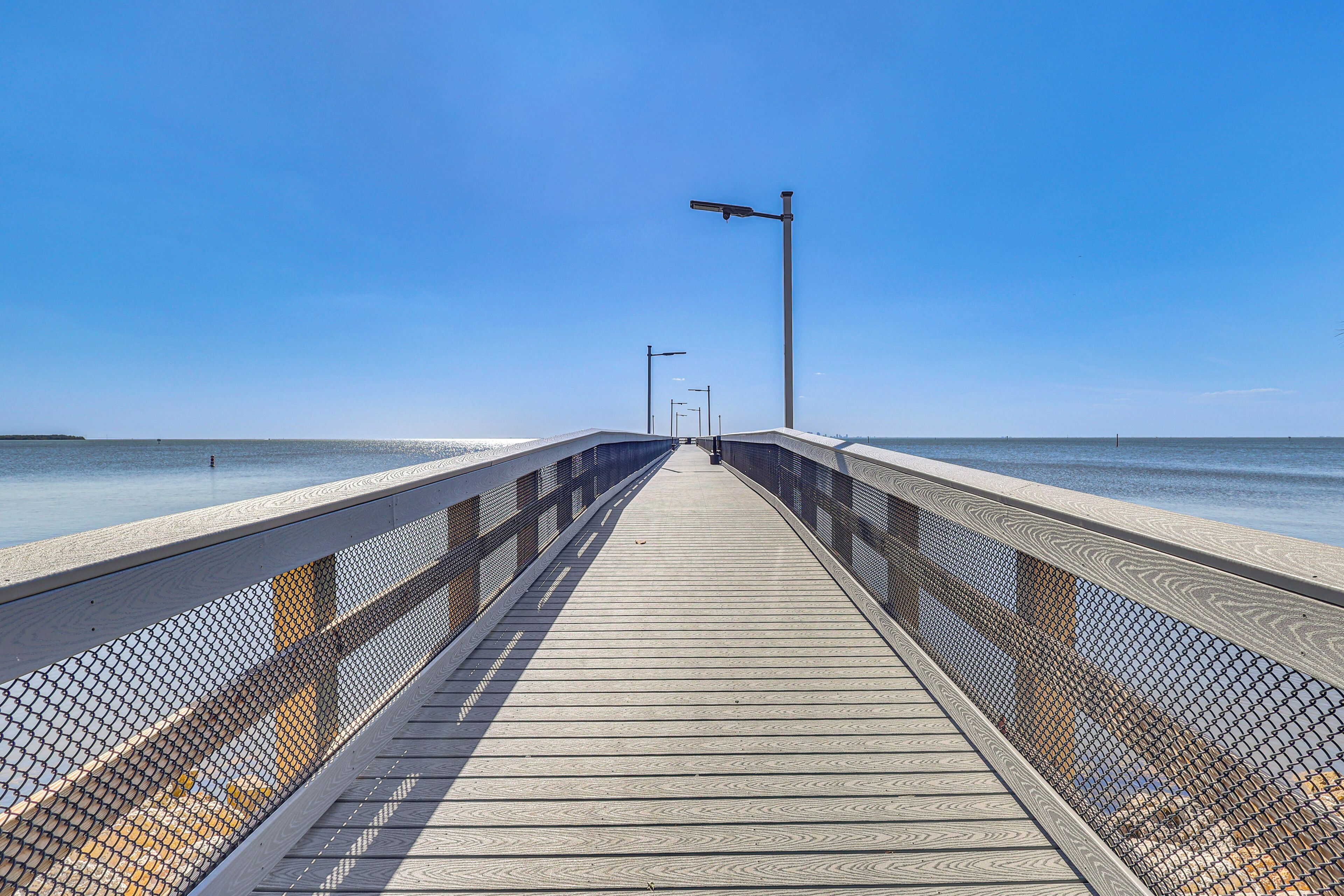 A wooden boardwalk leading to the beach with a clear sky.