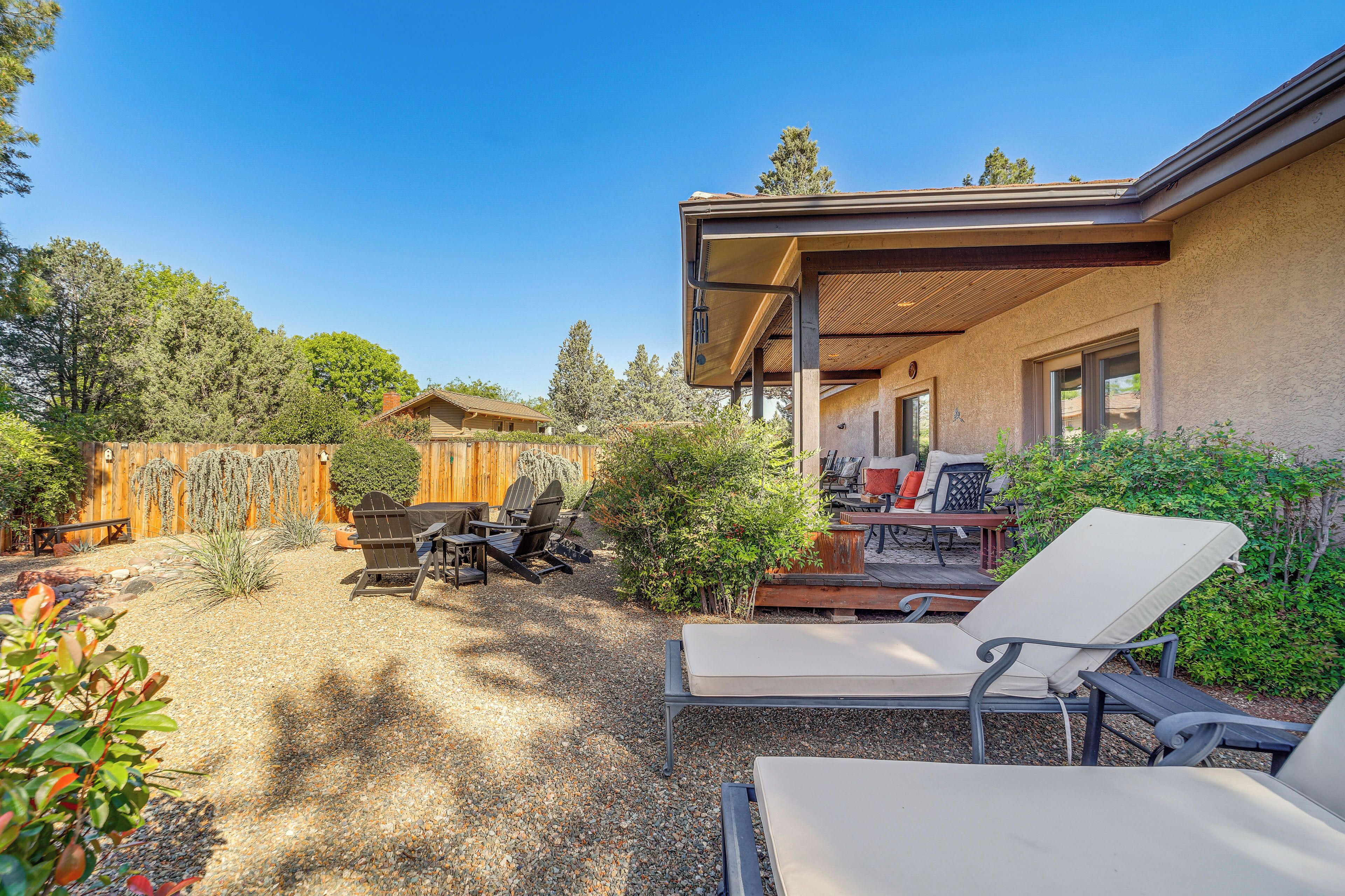 A covered outdoor seating area with lounge chairs and a wooden deck.