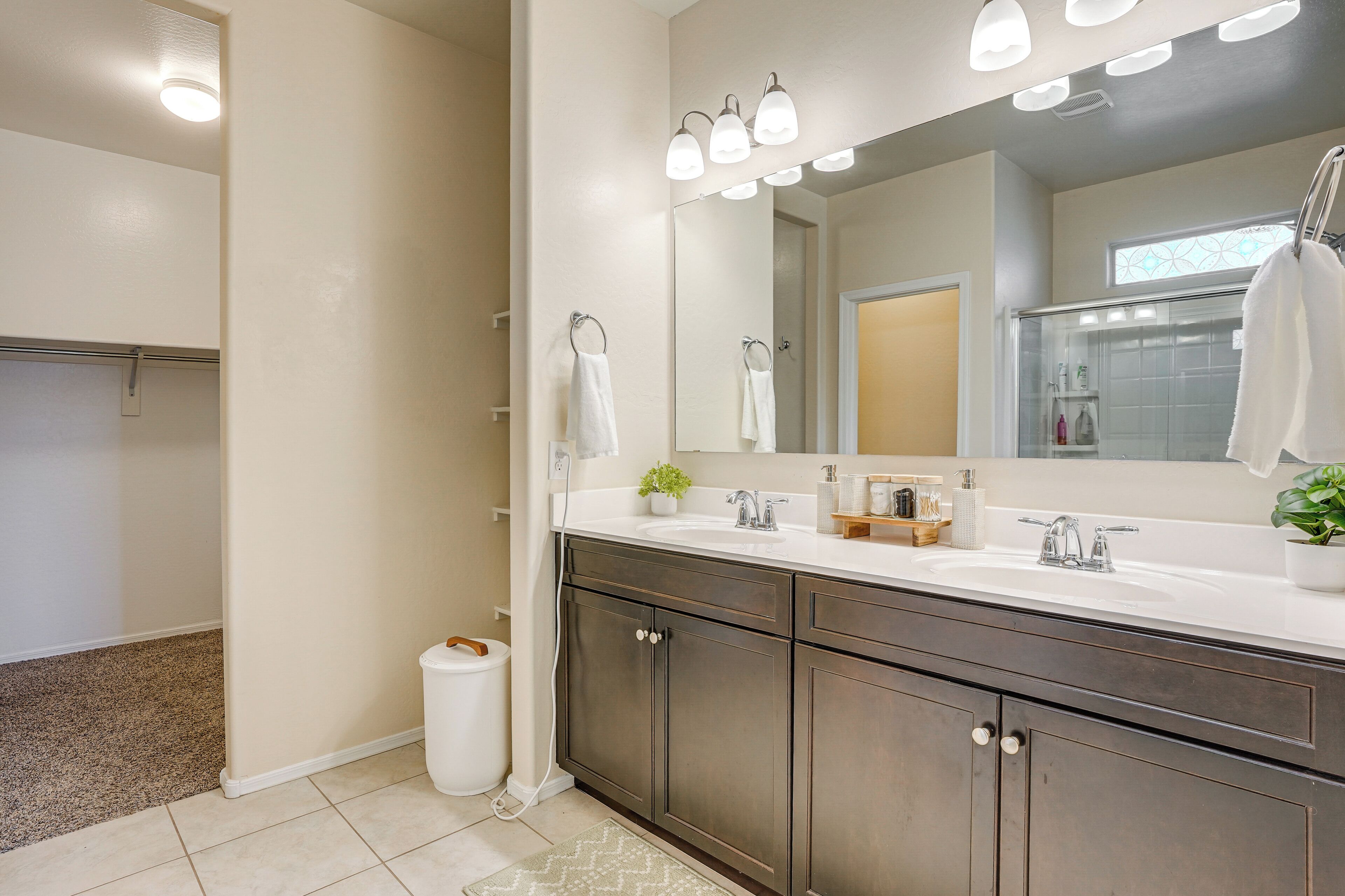Une salle de bain avec un grand miroir, un lavabo et une douche.