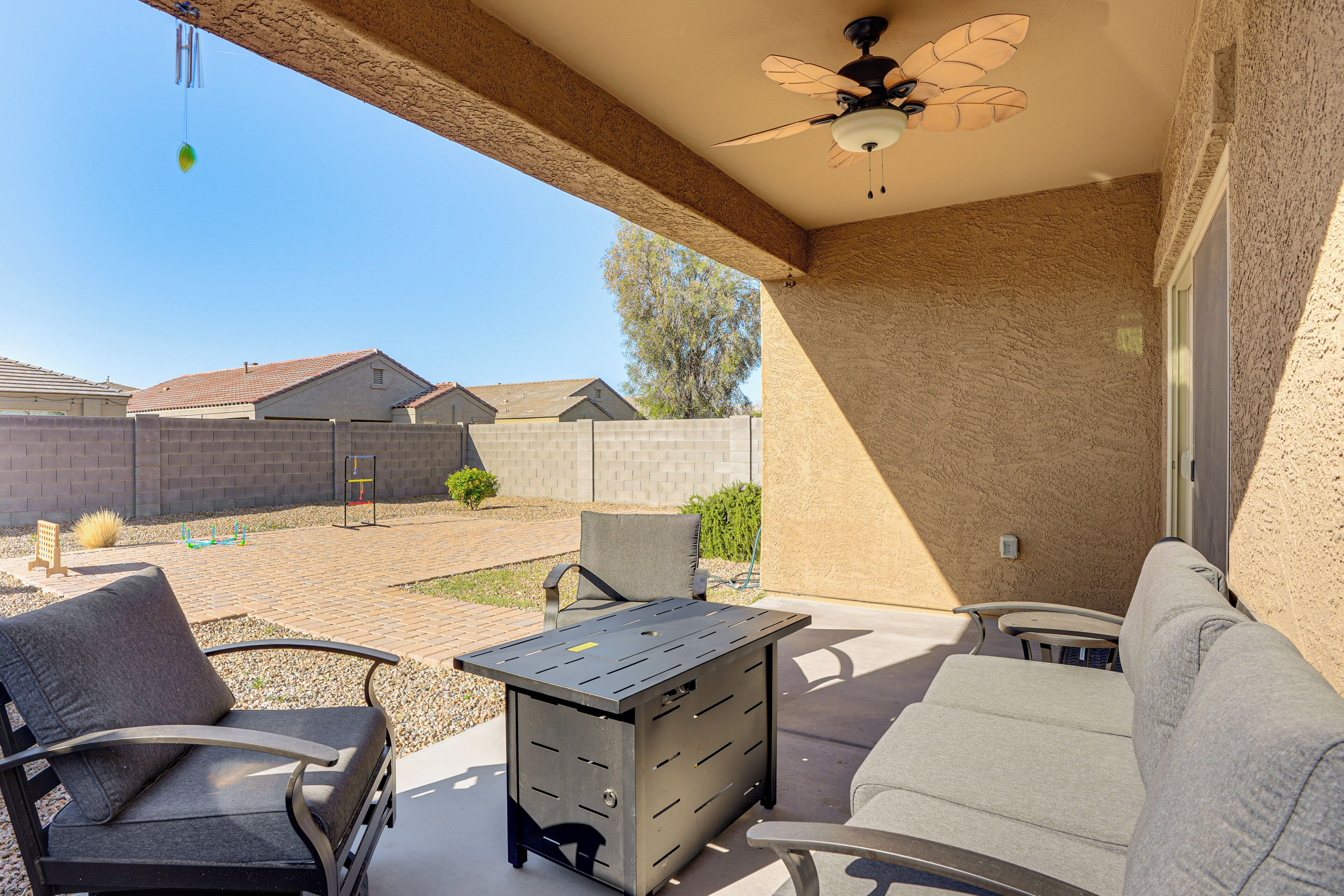 A patio area with a ceiling fan, a table, and two chairs.