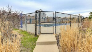 A fenced area with a concrete pathway leading to a gated entrance.