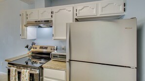 A kitchen with white cabinets, a stainless steel refrigerator, a stove, and a toaster oven. - 2 Private Patios! Family Home in Corpus Christi (Corpus Christi)