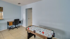 A room with a wooden table, a desk with drawers, a chair, and a door. - 2 Private Patios! Family Home in Corpus Christi (Corpus Christi)
