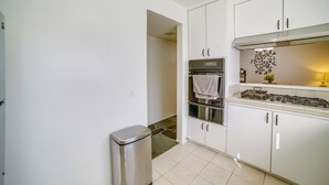 A kitchen with white cabinets, a stainless steel stove, and a trash bin. - Family Gem w/ Pet-friendly Yard! 8 Mi to Riverside (Moreno Valley)