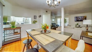 A modern kitchen with a dining area, wooden flooring, and a chandelier. - Family Gem w/ Pet-friendly Yard! 8 Mi to Riverside (Moreno Valley)