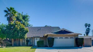 A single-story house with a garage, a front lawn, and a palm tree. - Family Gem w/ Pet-friendly Yard! 8 Mi to Riverside (Moreno Valley)