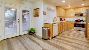 A kitchen with wooden cabinets, a stainless steel refrigerator, and a dishwasher. - Family Home 5 Mi to Dtwn Riverside & Hospital! (Riverside)