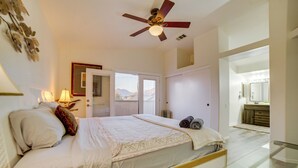 A bedroom with a bed, bedside lamp, ceiling fan, and a view of the outside. - Family Home 5 Mi to Dtwn Riverside & Hospital! (Riverside)