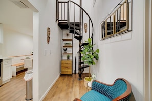 A modern interior with a spiral staircase, a kitchen with white cabinets, and a blue patterned chair. - 2 Mi to Dtwn Riverside & Hospital! Family Retreat (Riverside)