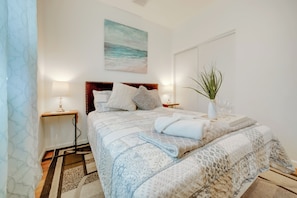 A bedroom with a bed, bedside tables, a nightstand, a plant, and a painting on the wall. - 2 Mi to Dtwn Riverside & Hospital! Family Retreat (Riverside)