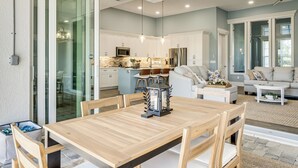 Una cocina moderna con armarios blancos, un refrigerador de acero inoxidable y un microondas integrado.