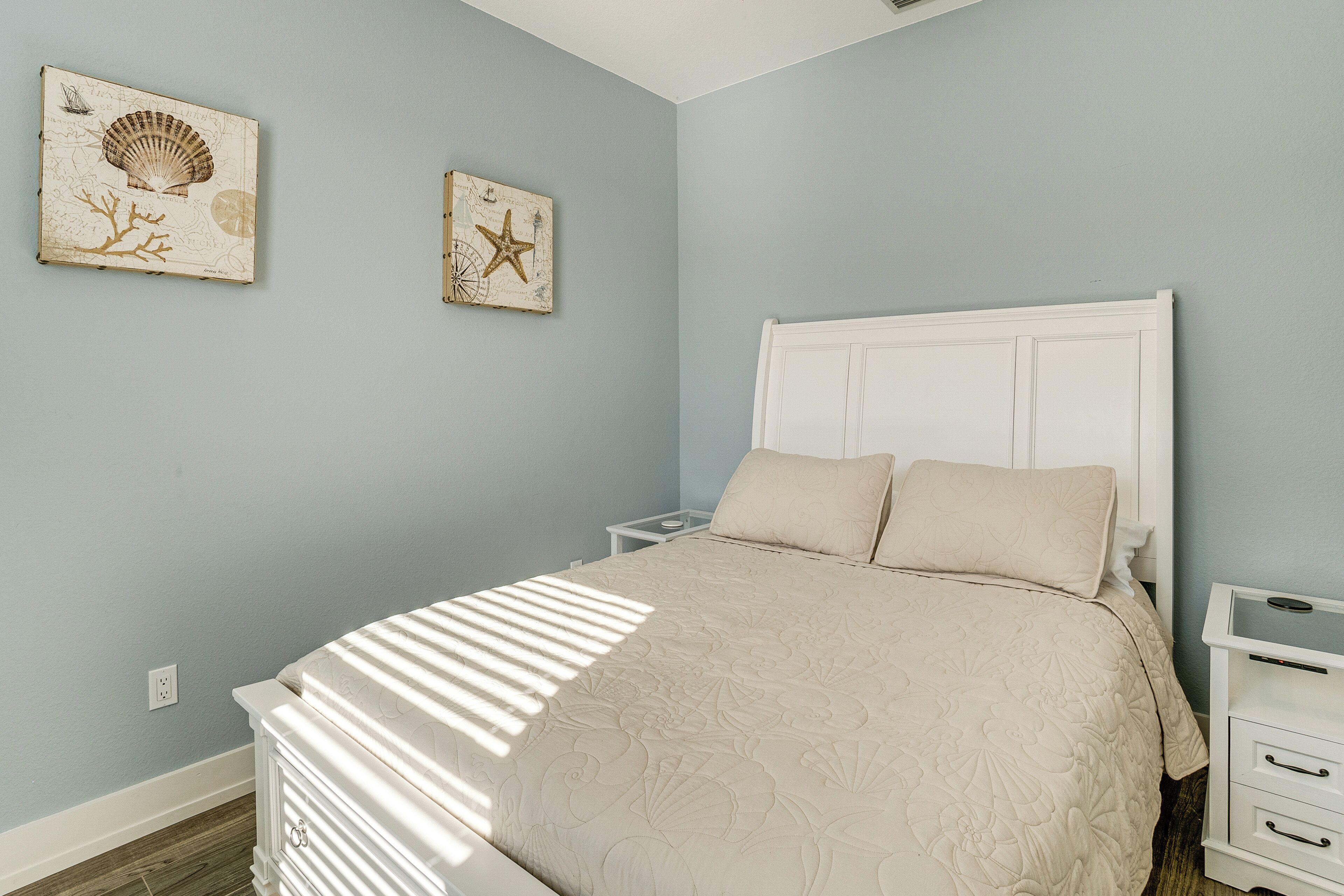 Un dormitorio con cama, mesitas de noche y decoración en la pared.